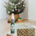Bottle of absolute green evergreen balsam air freshener with a christmas tree and christmas presents. woodsy scent 